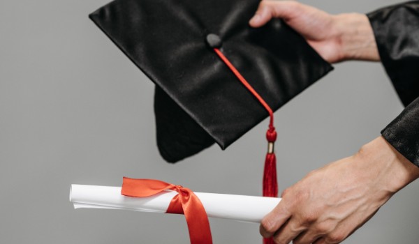 person holding mortarboard and parchment